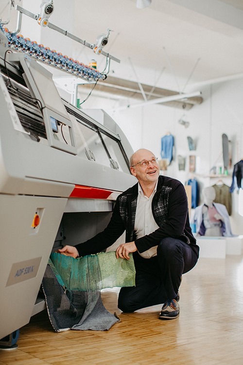 Knitting machinery and an operator pictured in Woolmark's whole-garment technology article.